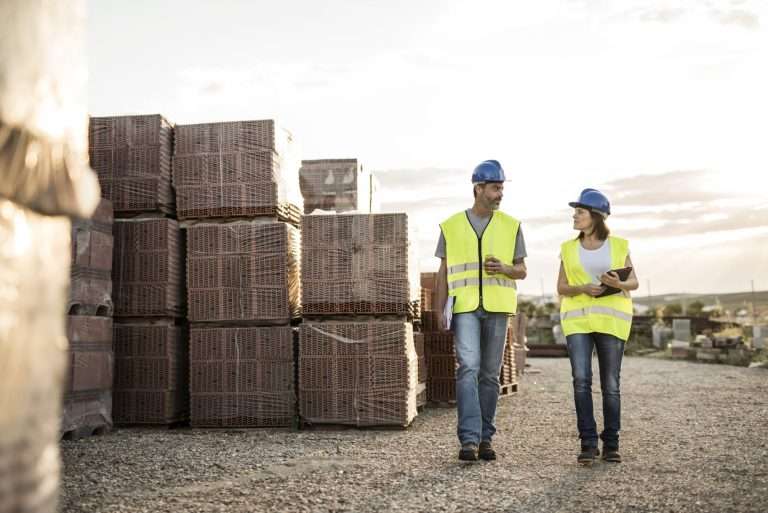 Construction managers reviewing pallets of materials delivered to a job site